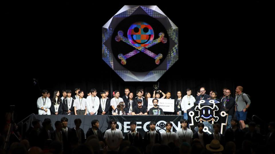 Team Atlanta stands on the dark DefCon stage during the convention&#039;s closing ceremony. 